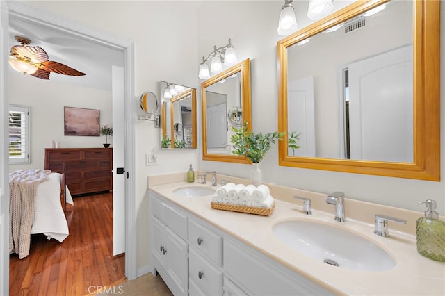 bathroom with hardwood / wood-style flooring, ceiling fan, and vanity