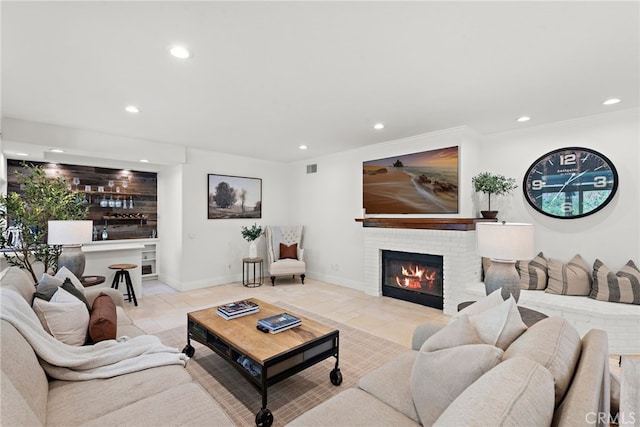 tiled living room featuring a brick fireplace and bar area