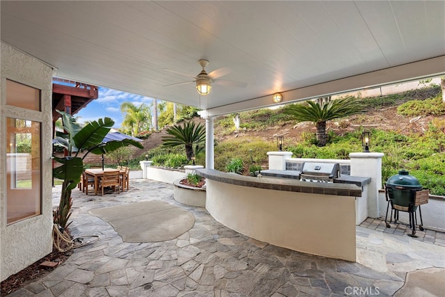 view of patio with ceiling fan, area for grilling, and grilling area