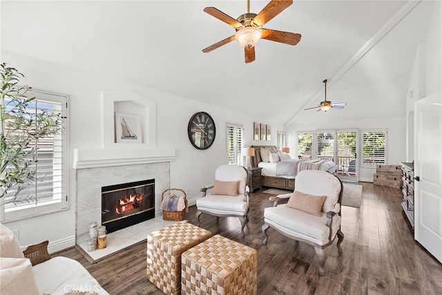 bedroom with ceiling fan, a high end fireplace, dark hardwood / wood-style floors, and high vaulted ceiling