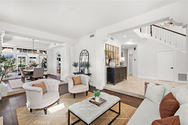 living room featuring light hardwood / wood-style floors and ornate columns