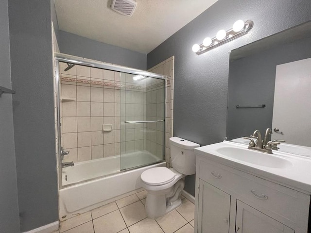 full bathroom with tile patterned flooring, vanity, enclosed tub / shower combo, and toilet