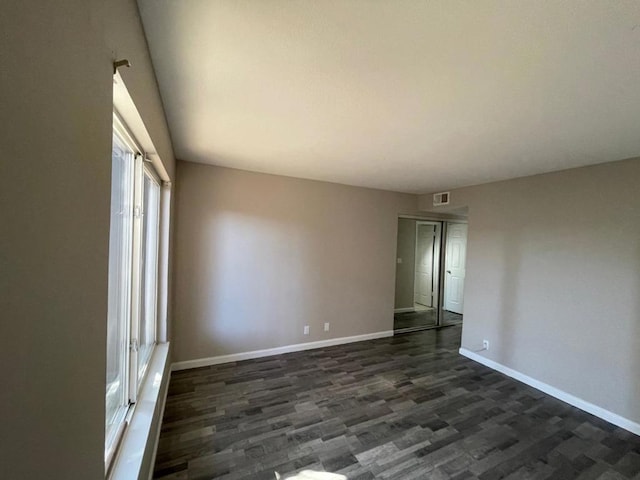 empty room with dark hardwood / wood-style flooring