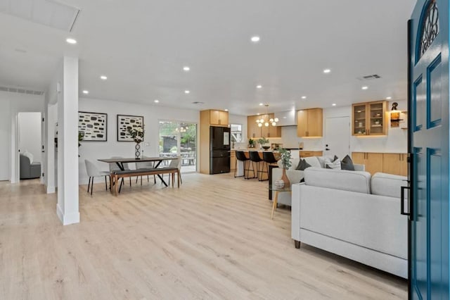 living room with an inviting chandelier and light wood-type flooring