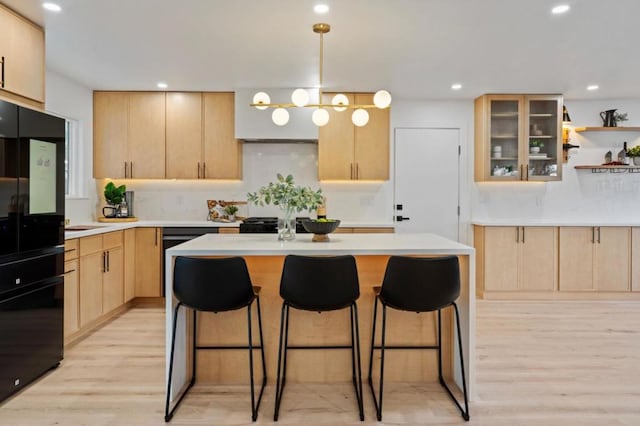 kitchen with a center island, light hardwood / wood-style floors, and light brown cabinets