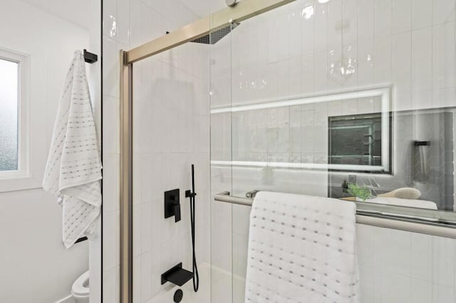 bathroom with toilet and an enclosed shower