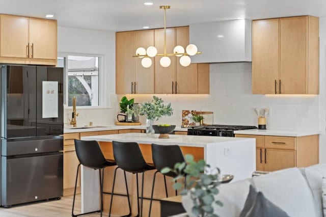 kitchen featuring pendant lighting, light brown cabinets, and black fridge