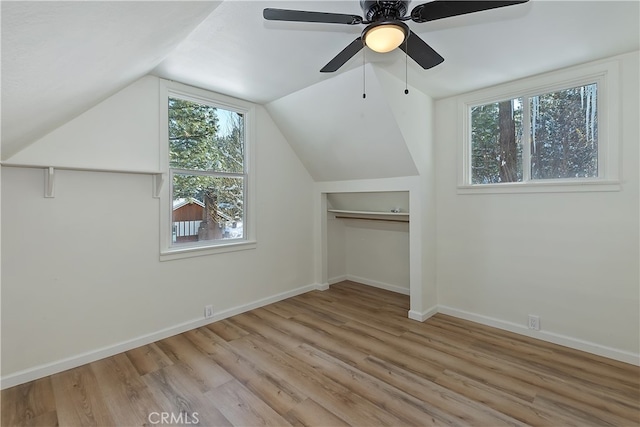 additional living space with ceiling fan, lofted ceiling, and light wood-type flooring