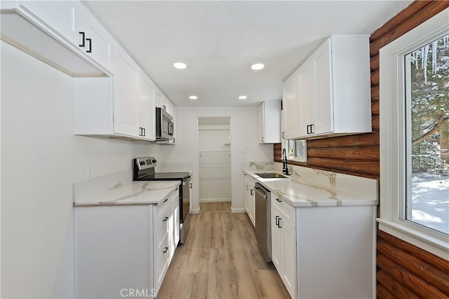 kitchen featuring sink, plenty of natural light, stainless steel appliances, and white cabinets