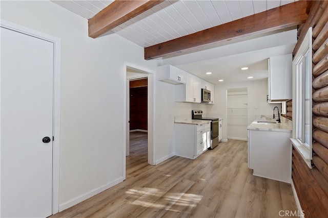 kitchen with sink, white cabinetry, beam ceiling, stainless steel appliances, and light hardwood / wood-style floors