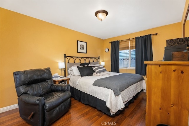 bedroom with dark hardwood / wood-style flooring