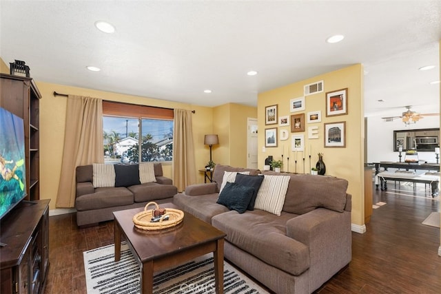 living room with dark wood-type flooring and ceiling fan