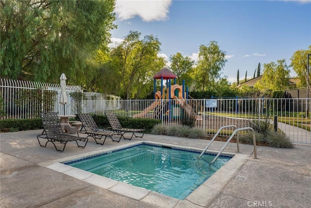 view of pool with a playground and a patio