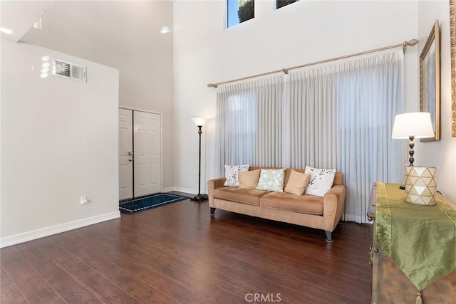 living room with dark hardwood / wood-style floors and a high ceiling