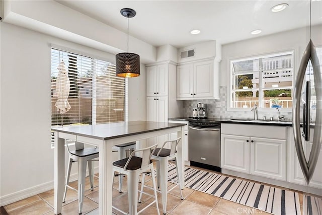 kitchen featuring white cabinetry, light tile patterned floors, decorative light fixtures, and stainless steel appliances