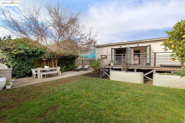 view of yard featuring a wooden deck and a patio