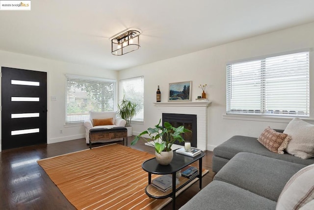 living room with dark wood-type flooring and a fireplace