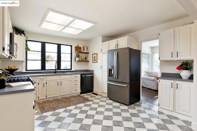 kitchen featuring stainless steel appliances, white cabinetry, and sink