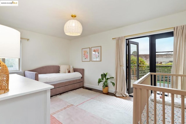 bedroom with wood-type flooring and access to outside