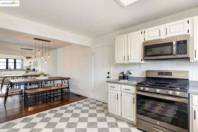 kitchen featuring pendant lighting, a notable chandelier, white cabinets, and appliances with stainless steel finishes