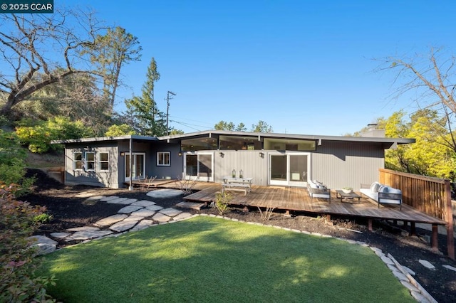 rear view of property with a wooden deck and a yard