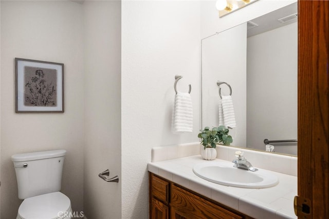 bathroom with visible vents, vanity, and toilet