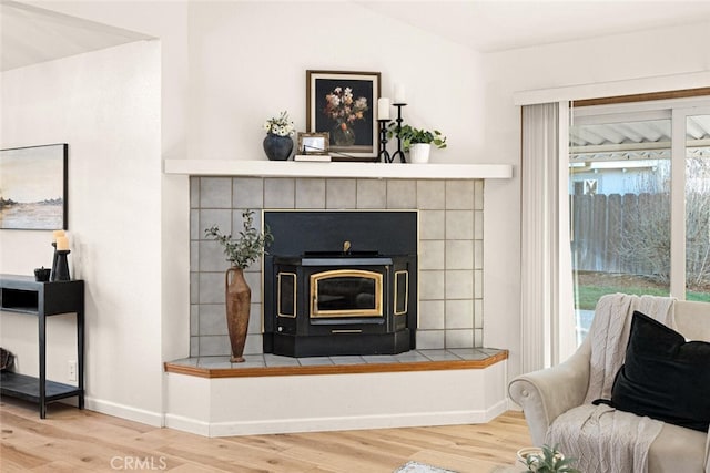 details with a wood stove, baseboards, and wood finished floors