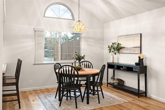 dining area with a healthy amount of sunlight, a notable chandelier, baseboards, and wood finished floors