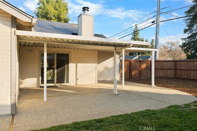 back of house featuring a chimney, a patio area, and fence