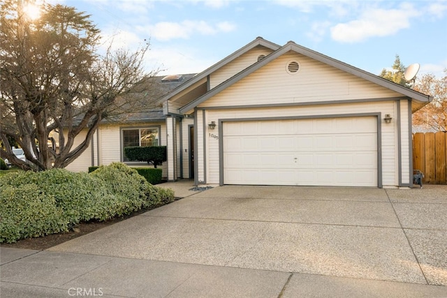 single story home featuring driveway, an attached garage, and fence