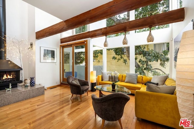 sunroom with a wood stove and beam ceiling