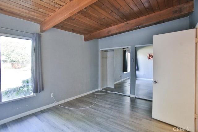 unfurnished bedroom with wood ceiling, beam ceiling, dark wood-type flooring, and a closet