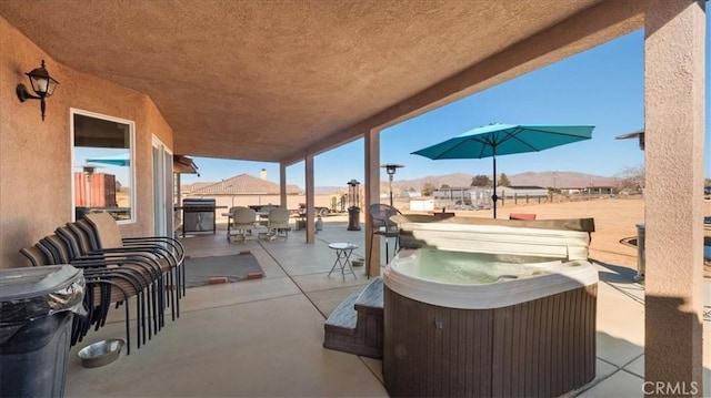 view of patio featuring a hot tub and a mountain view