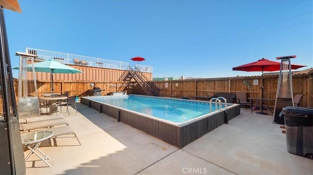 view of swimming pool featuring a hot tub and a patio