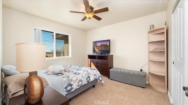 carpeted bedroom featuring ceiling fan and a closet