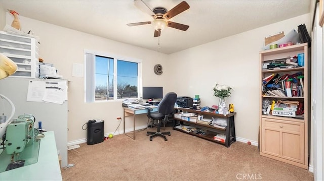 carpeted home office featuring ceiling fan