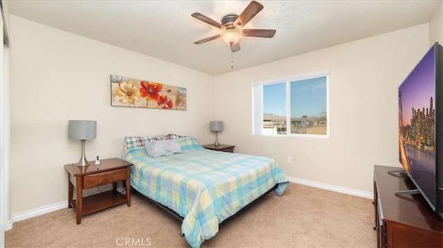 bedroom with ceiling fan and light carpet