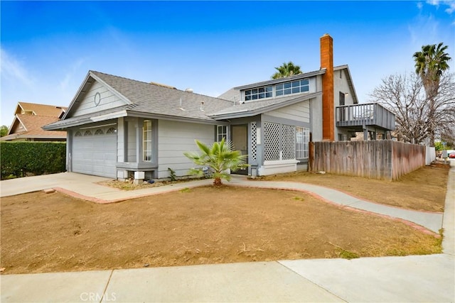 view of front of home with a shingled roof, driveway, an attached garage, and fence