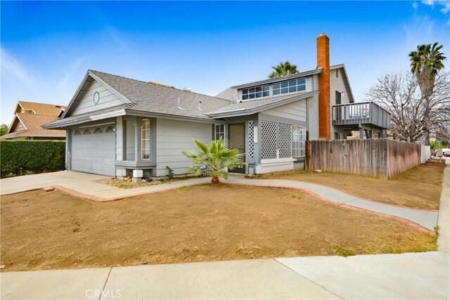 13031 Eyota Dr, Moreno Valley, CA 92555 - view of front of house featuring a chimney, fence, a garage, concrete driveway, and a shingled roof