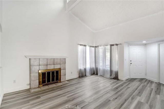 13031 Eyota Dr, Moreno Valley, CA 92555 - unfurnished living room featuring high vaulted ceiling, a tile fireplace, wood finished floors, baseboards, and beam ceiling