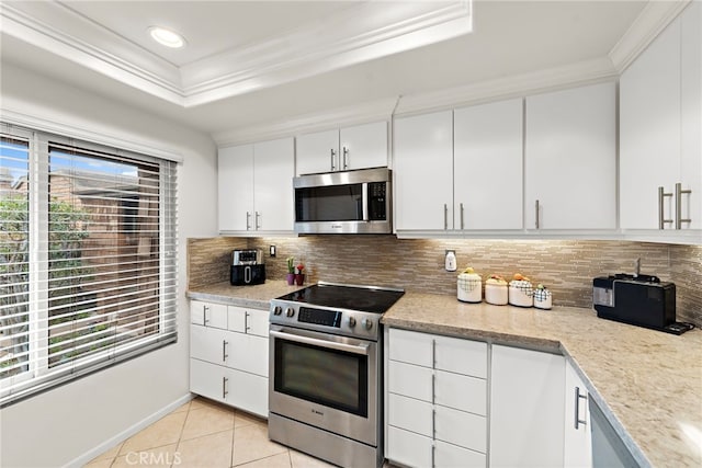 kitchen featuring crown molding, appliances with stainless steel finishes, light tile patterned flooring, and white cabinets