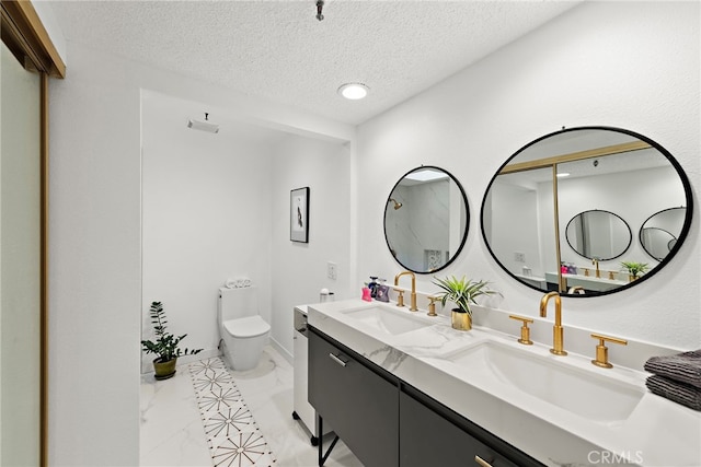 full bath with marble finish floor, a sink, a textured ceiling, and toilet