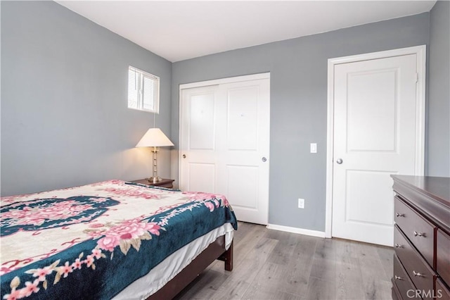 bedroom with light hardwood / wood-style floors and a closet