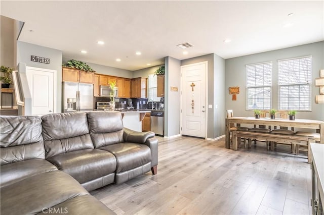 living room featuring sink and light hardwood / wood-style floors