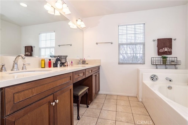 bathroom featuring tile patterned flooring, vanity, and tiled bath