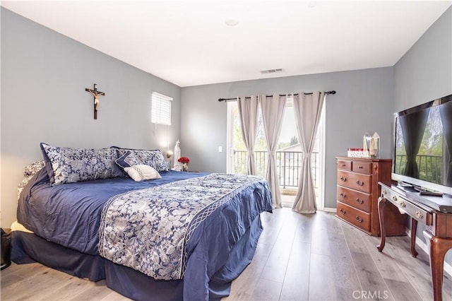 bedroom with access to exterior and light hardwood / wood-style floors