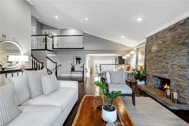 living room with high vaulted ceiling, hardwood / wood-style flooring, a fireplace, and ornamental molding