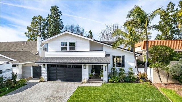 view of front of house featuring a garage and a front lawn