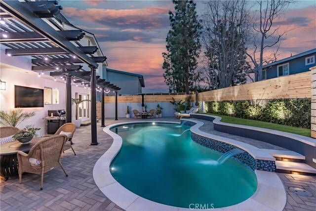 pool at dusk with pool water feature, a patio area, and a pergola