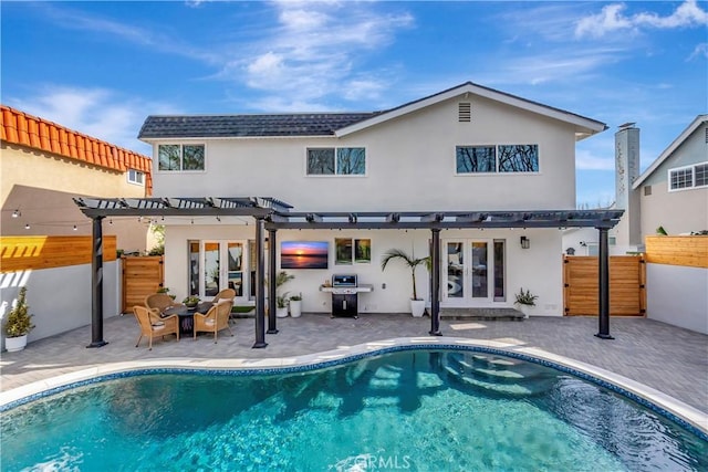 rear view of property with french doors, a patio, and a pergola